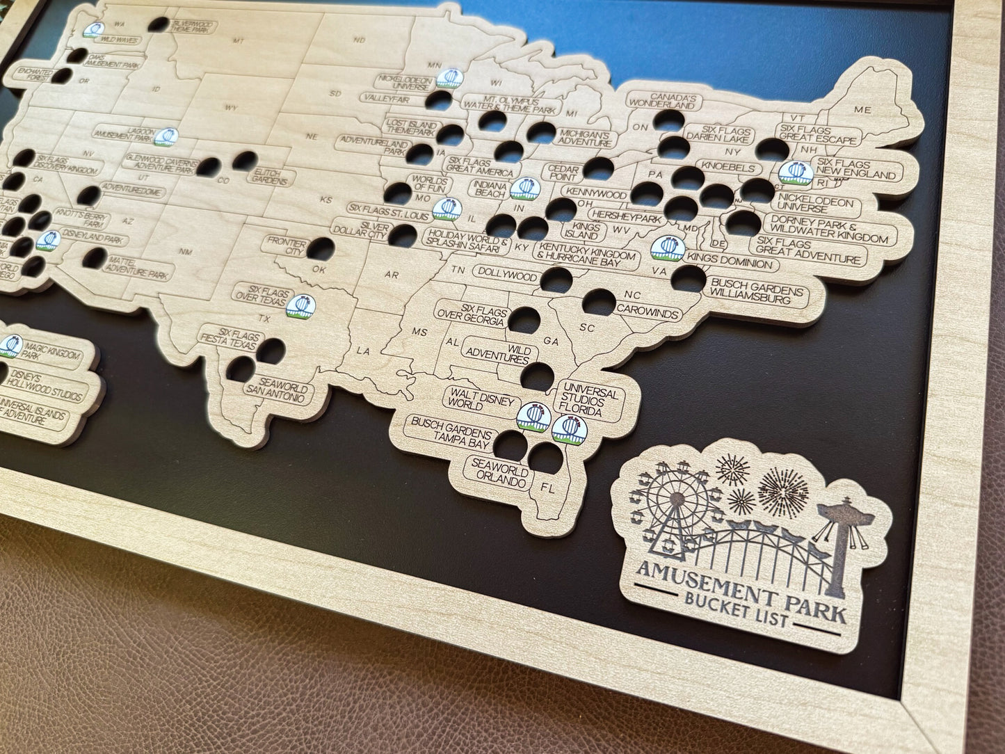 Map of amusement parks with pins and a logo on a wooden board